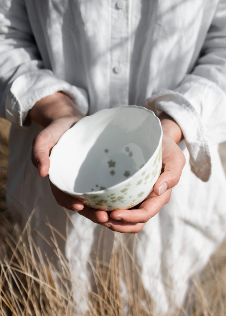 Slåpeblom skål holdes i hender i sivet
